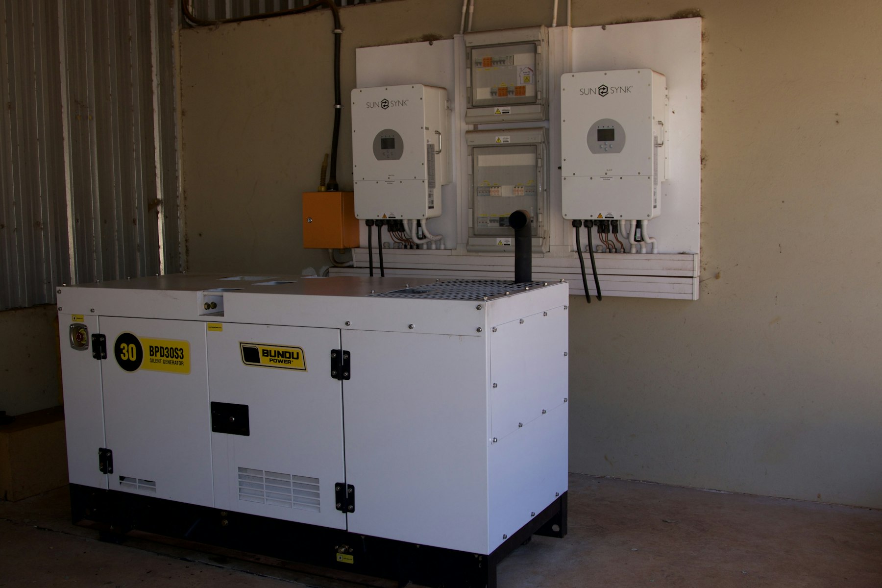 Backup generator beside wall-mounted power inverters