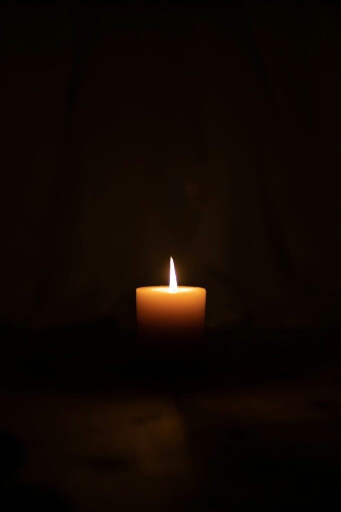 Lit candle in a dark room during a power outage