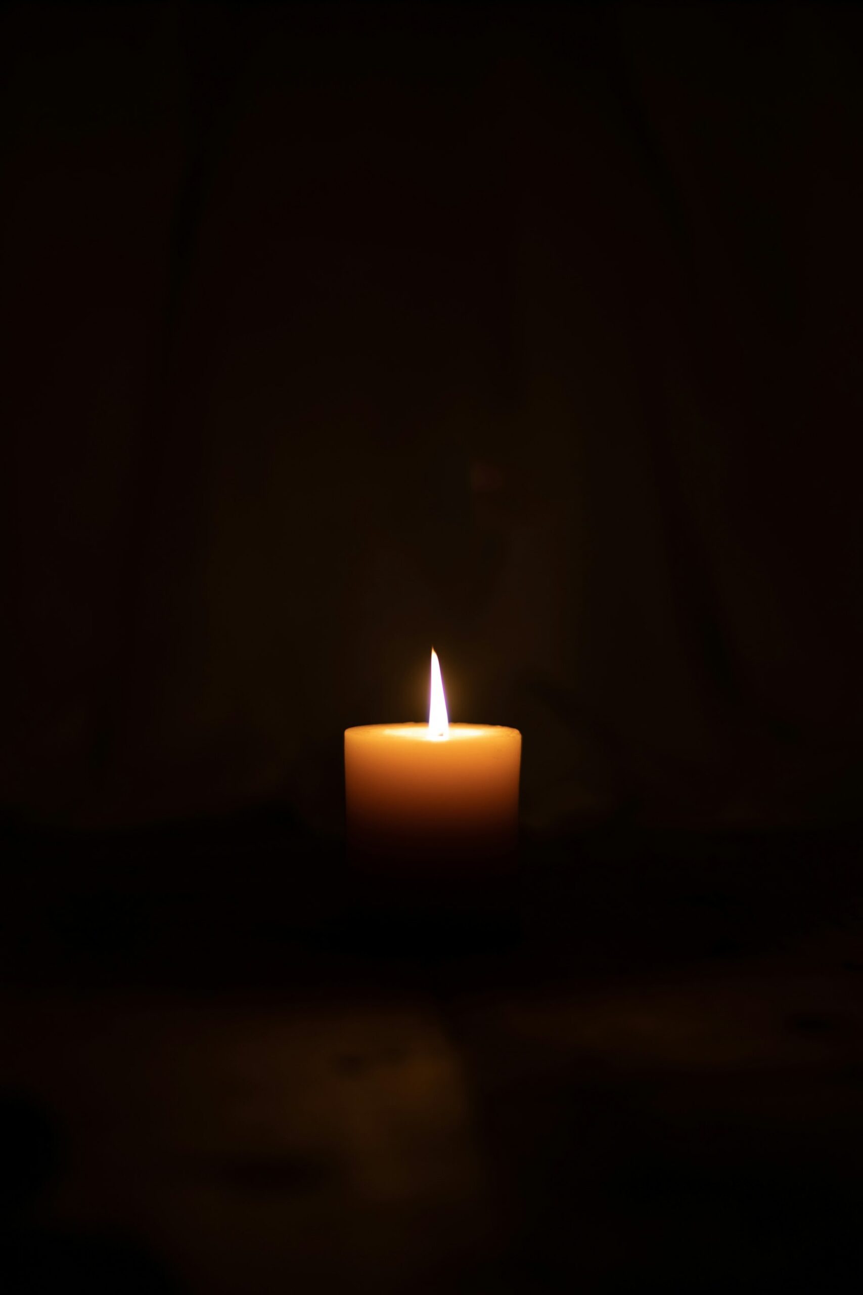 Lit candle in a dark room during a power outage