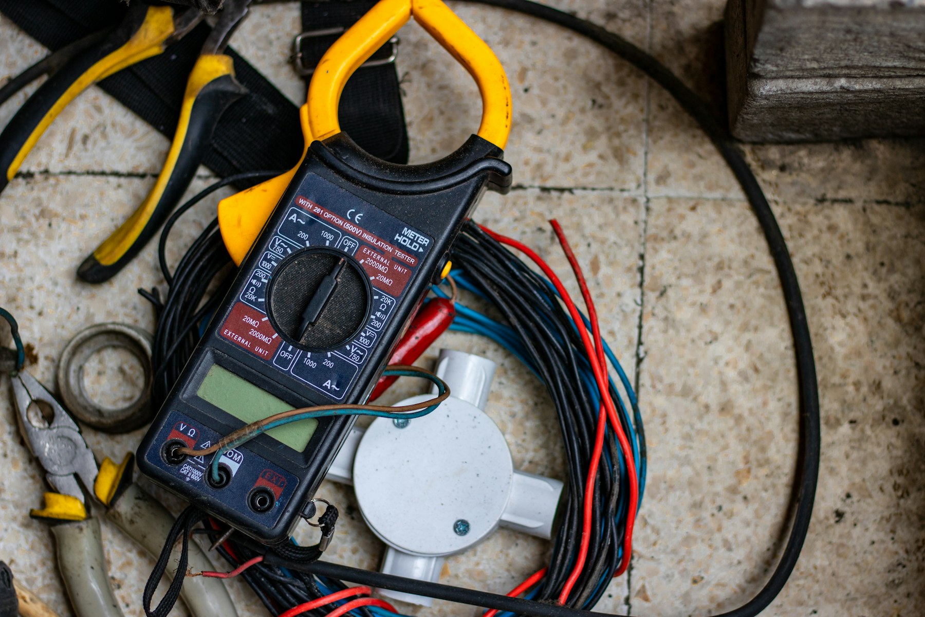 Black and yellow clamp meter used for electrical testing