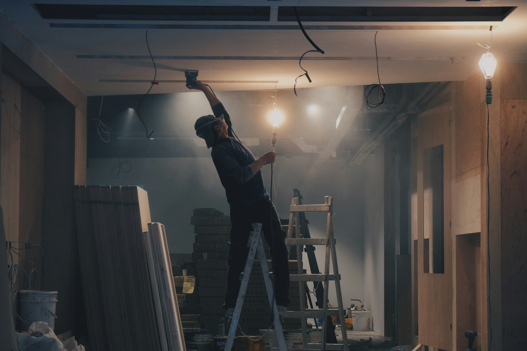 Electrician working on a ladder near the ceiling