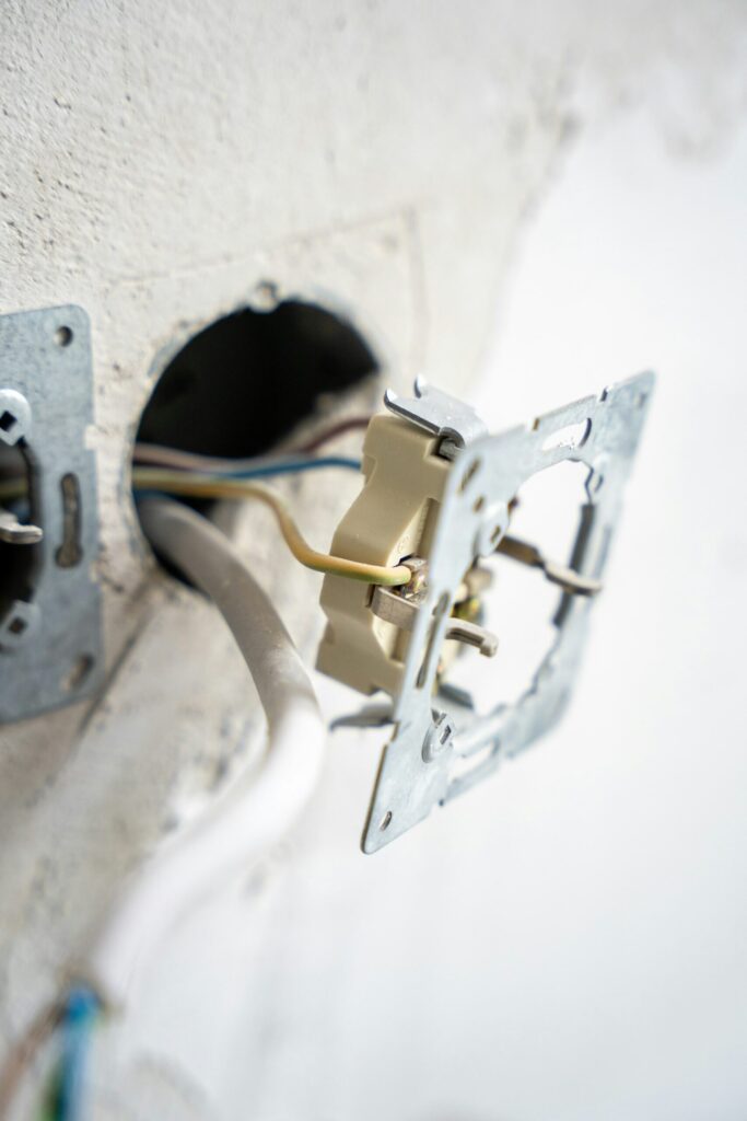 Exposed electrical wiring inside a wall during repair